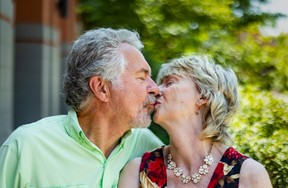 Marnie Wilson kisses her husband Paul as they pose for a photo in Toronto's Liberty Village on Tuesday July 29, 2025. Back on July 31st, 1975, Marnie called in sick to work, went to the beach and ended up on the front page of the Toronto Sun.