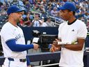 Canadian tennis star Felix Auger-Aliassime (right) talks with George Springer of the Toronto Blue Jays before the start of a MLB game in Toronto on July 22, 2025.