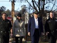 President Donald Trump, center right, and first lady Melania Trump walk, center left, walk with Jason Hing, chief deputy of emergency services at the Los Angles Fire Department, left, and Capt. Jeff Brown, Chief of Station 69, as they tour the Pacific Palisades neighborhood affected by recent wildfires in Los Angeles, Jan. 24, 2025.