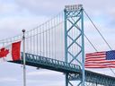 Canadian and American flags fly near the Ambassador Bridge at the Canada-USA border crossing in Windsor, Ont. on Saturday, March 21, 2020.