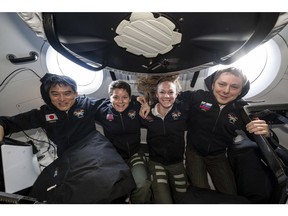This image provided by NASA shows, from left, NASA's SpaceX Crew-10 members JAXA (Japan Aerospace Exploration Agency) astronaut Takuya Onishi, NASA astronauts Anne McClain and Nichole Ayers, and Roscosmos cosmonaut Kirill Peskov posing for a portrait inside the SpaceX Dragon crew spacecraft that carried them to the International Space Station and will return them back to Earth. (NASA via AP)