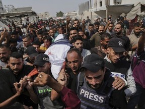 Palestinians carry the body of Al Jazeera correspondent