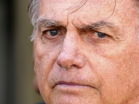 Brazil's former President Jair Bolsonaro, center, temporarily allowed out of house arrest for medical exams, departs a hospital in Brasília, Brazil, Saturday, Aug. 16, 2025.