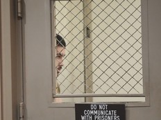 Raymond Boodarian hides behind a door.