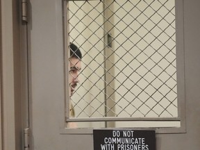 Raymond Boodarian hides behind a door.
