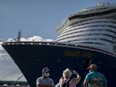 Tourists take pictures after exiting Carnival's Mardi Gras cruise ship, docked in the bay of San Juan, Puerto Rico, Tuesday, Aug. 3, 2021, marking the first time a cruise ship visits the U.S. territory since the COVID-19 pandemic began.