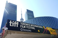 A sign for the 2024 Toronto International Film Festival Festival is pictured in front of the CN Tower on the opening day of the festival, Thursday, Sept. 5, 2024, in Toronto.