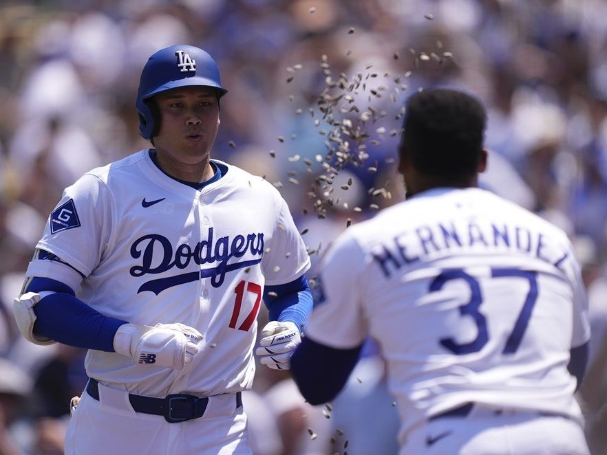 Los Angeles Dodgers' Shohei Ohtani, left, has seeds tossed at him by Teoscar Hernández after hitting a two-run home run during the third inning against the St. Louis Cardinals, Wednesday, Aug. 6, 2025, in Los Angeles. 