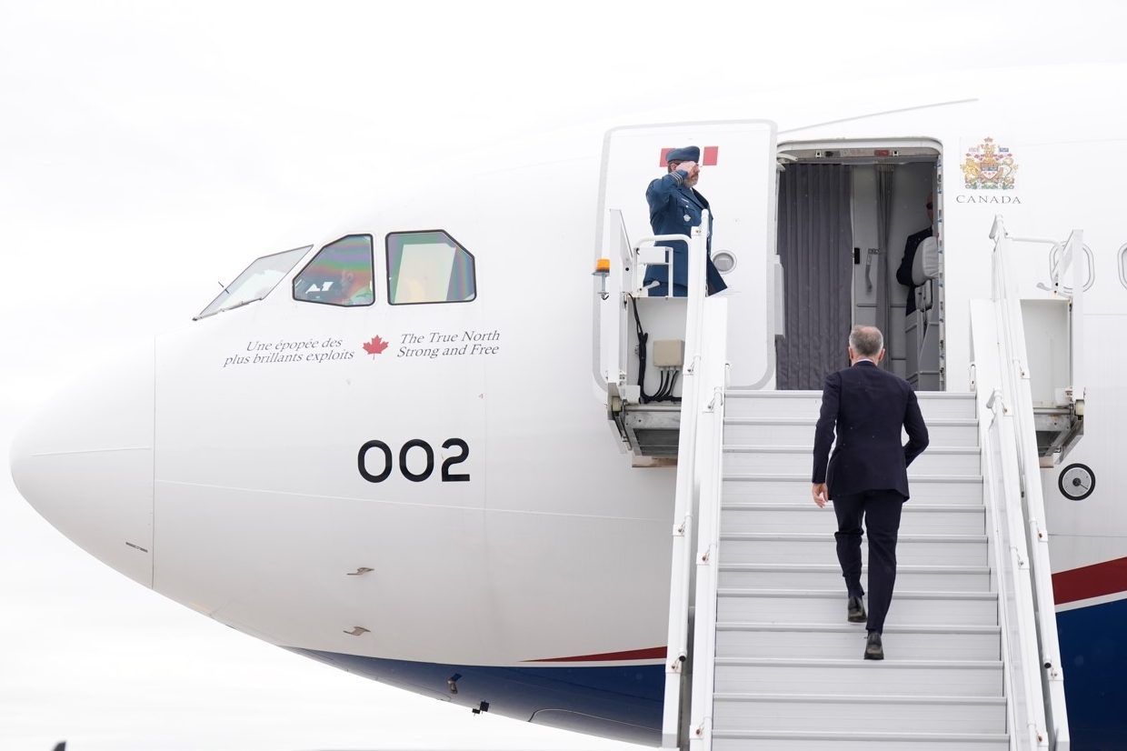 Prime Minister Mark Carney boards a government plane on Monday, May 5, 2025.