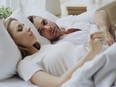 Closeup of couple with relationship problems having emotional conversation while lying in bed.