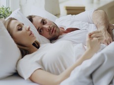 Closeup of couple with relationship problems having emotional conversation while lying in bed.