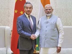 Indian Prime Minister Narendra Modi shakes hand with Chinese Foreign Minister Wang Yi.