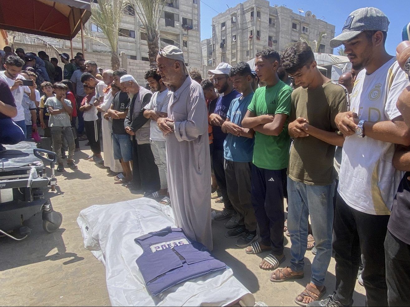 In this family handout photo, Riyad Dagga, center, and other relatives and friends pray over the body of his daughter, freelance journalist Mariam Dagga, 33, during her funeral after she was killed in a double Israeli strike on Nasser Hospital in Khan Younis, southern Gaza Strip, Monday, Aug. 25, 2025.