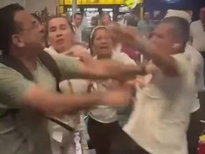 People pushing man after he slapped woman in face at Colombia airport.