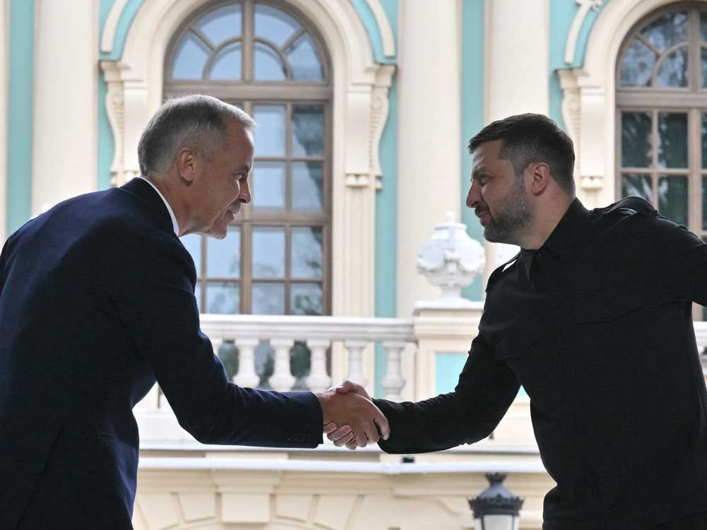 Ukrainian President Volodymyr Zelensky (right) and Prime Minister Mark Carney shake hands during their press-conference following the talks outside Mariyinsky Palace in Kyiv on Aug. 24, 2025, amid Russian invasion in Ukraine.