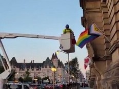 Posted to social media by Dacey Media, this image shows workers taking down a Canadian flag and putting up the Pride flag at the Prime Minister's Office in Ottawa.