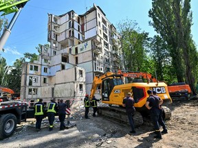 Rescuers work outside a residential building in Kyiv on August 1, 2025, partially destroyed following a Russian missile strike morning on July 31, 2025, amid Russian invasion in Ukraine.