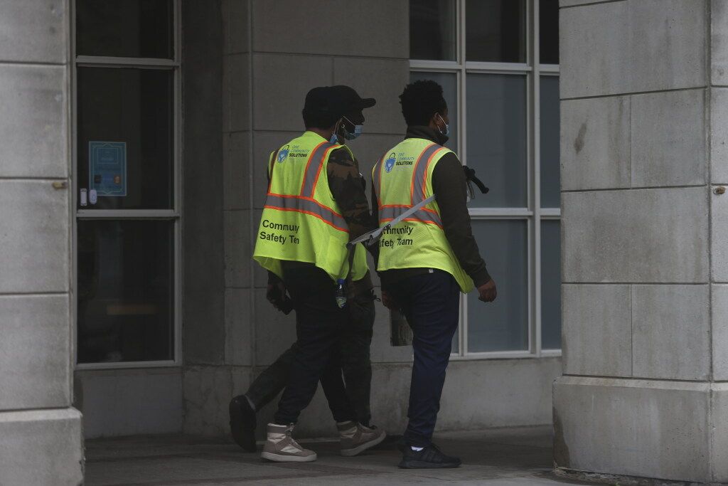 A One Community Solutions community safety team patrols the perimeter of the downtown Novotel on October 14, 2021.