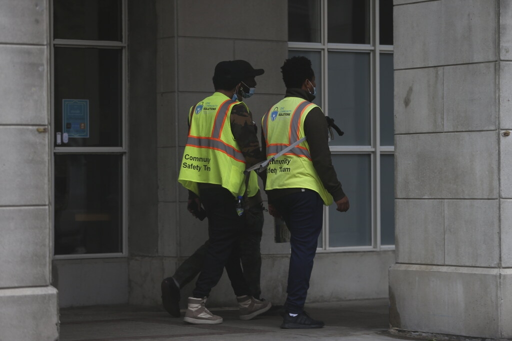  A One Community Solutions community safety team patrols the perimeter of the downtown Novotel on October 14, 2021.