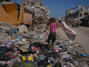 Malak Sobh, 7, searches through garbage for plastic to use as cooking fuel next to a makeshift tent camp for displaced Palestinians, where members of the Sobh family are taking shelter, in Gaza City on Thursday, July 24, 2025.
