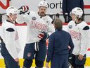 USA players Austin Matthews (center), Jack Eichel (left) and Jack Hughes (right) speak with the coaching staff during a Four Nations match.