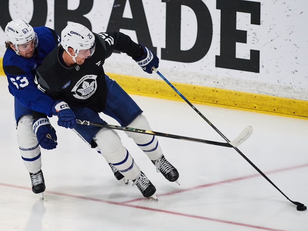 Toronto Maple Leafs defenceman Brandon Carlo battles against forward Matias Maccelli (63) during training camp.