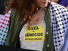 A woman wears a sticker critical of Israel.