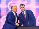 Right-wing activist Charlie Kirk speaks on stage with President Donald Trump at America Fest 2024 in Phoenix, Arizona, on Dec. 22, 2024.