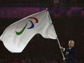 International Paralympic Committee president Andrew Parsons waves the movement's flag at the closing ceremony of the 2024 Summer Paralympics in Paris.