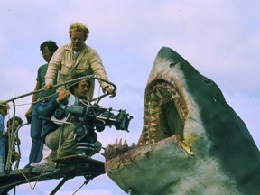 This image released by Peacock shows cinematographer Bill Butler, standing, and director Steven Spielberg during the filming of “Jaws.” (Peacock/Universal Pictures via AP)