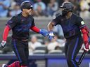 Blue Jays’ George Springer (left) celebrates scoring with teammate Vladimir Guerrero Jr. against the Tampa Bay Rays at the Rogers Centre last night.