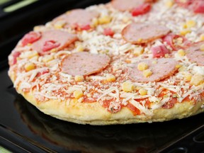 Frozen pizza with salami, cheese, corn and pepper.