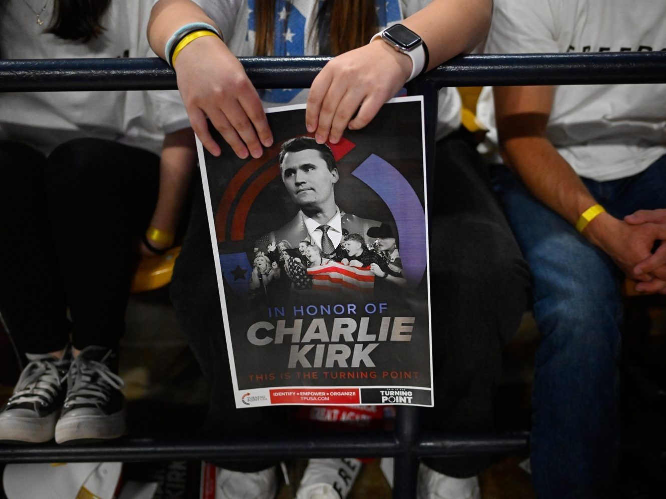 An attendee holds a poster of Charlie Kirk at a Turning Point USA rally.