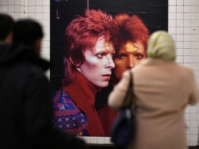 People walk by a David Bowie art installation in New York City.