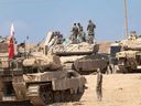 Israeli soldiers arrange equipment on tanks at a staging point near the border with the Gaza Strip on Sept. 17, 2025 in Southern Israel, Israel.