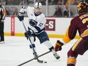 Penn State winger Gavin McKenna carries the puck in front of Arizona State Bennett Schimek during an NCAA college hockey game on Oct. 3, 2025.
