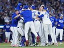 Toronto Blue Jays players celebrate on the field after defeating the Seattle Mariners in game seven of the American League Championship Series.