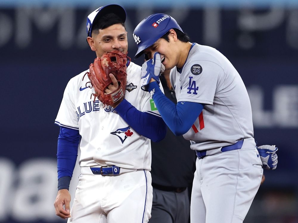 Shohei Ohtani of the Los Angeles Dodgers talks with Andres Jimenez of the Toronto Blue Jays during Game 2 of the World Series.