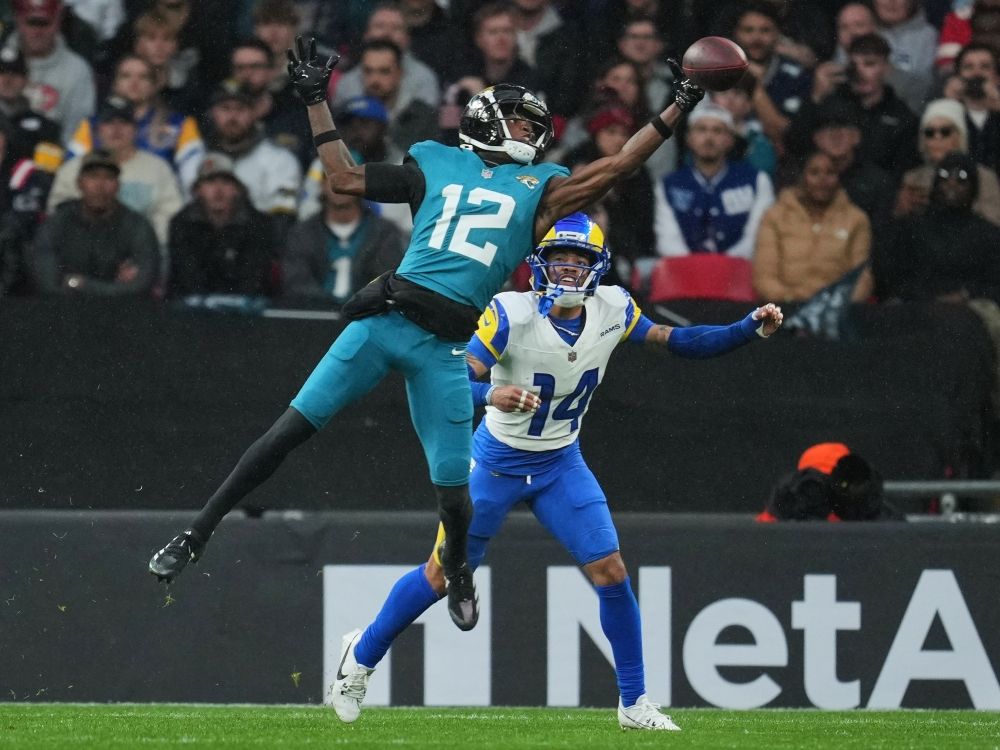 Jacksonville Jaguars wide receiver Travis Hunter (12) reaches to catch the ball as Los Angeles Rams cornerback Kobe Durant (14) makes the challenge.