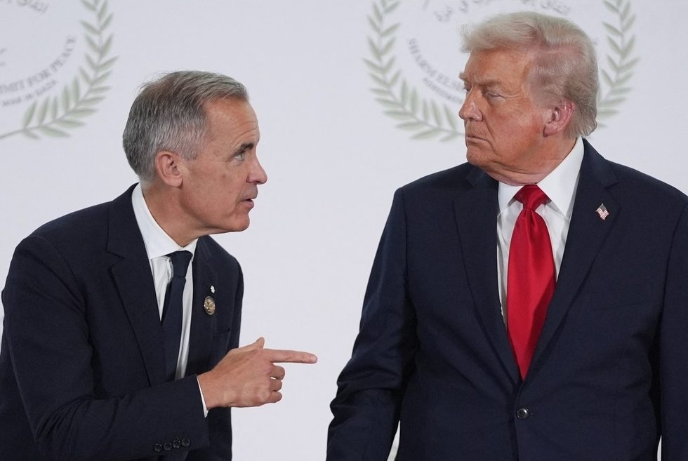  US President Donald Trump greets Canada’s Prime Minister Mark Carney during a summit on Gaza in Sharm el-Sheikh on October 13, 2025. (Photo by Evan Vucci / POOL / AFP)