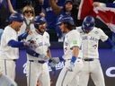 Addison Barger #47 of the Toronto Blue Jays is welcomed home after hitting a grand slam home run against the Los Angeles Dodgers during the sixth inning of Game 1 of the 2025 World Series at Rogers Center on October 24, 2025 in Toronto.