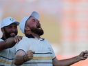 European Shane Lowry celebrates with Jon Rahm after hitting the winning putt on the 18th hole during singles play at Bethpage Black Golf Course during the Ryder Cup golf tournament on Sunday, September 28, 2025, in Farmingdale, New York.