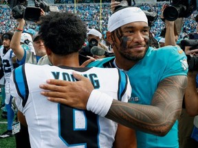 Miami Dolphins quarterback Tua Tagovailoa hugs Carolina Panthers quarterback Bryce Young after an NFL football game, Sunday, Oct. 5, 2025, in Charlotte, N.C.