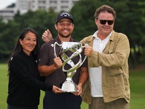 Xander Schauffele of the United States poses for a photo with his parents, Chen Ping-Yi, left, and Stefan Schauffele as he won the Baycurrent Classic golf tournament at Yokohama Country Club in Yokohama, near Tokyo, Sunday, October 12, 2025.