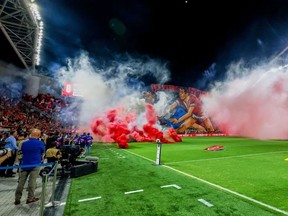 Smoke from torches thrown by fans filled the field before the soccer derby between Maccabi Tel Aviv and Hapoel Tel Aviv was canceled on Sunday after disturbances before the game led police to deem it unsafe to proceed at Bloomfield Stadium in Tel Aviv, Israel, Sunday, October 19, 2025.