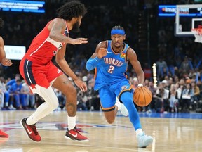 Thunder guard Shai Gilgeous-Alexander, right, drives past Wizards forward Marvin Bagley III, left, during second half NBA action in Oklahoma City, Thursday, Oct. 30, 2025.