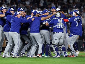 The Toronto Blue Jays celebrate on the field after defeating the New York Yankees in Game 4 of the American League Division Series at Yankee Stadium on Wednesday. Al Bello/Getty Images