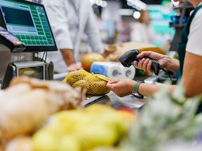 Supermarket cashier scanning potatoes at the checkout.