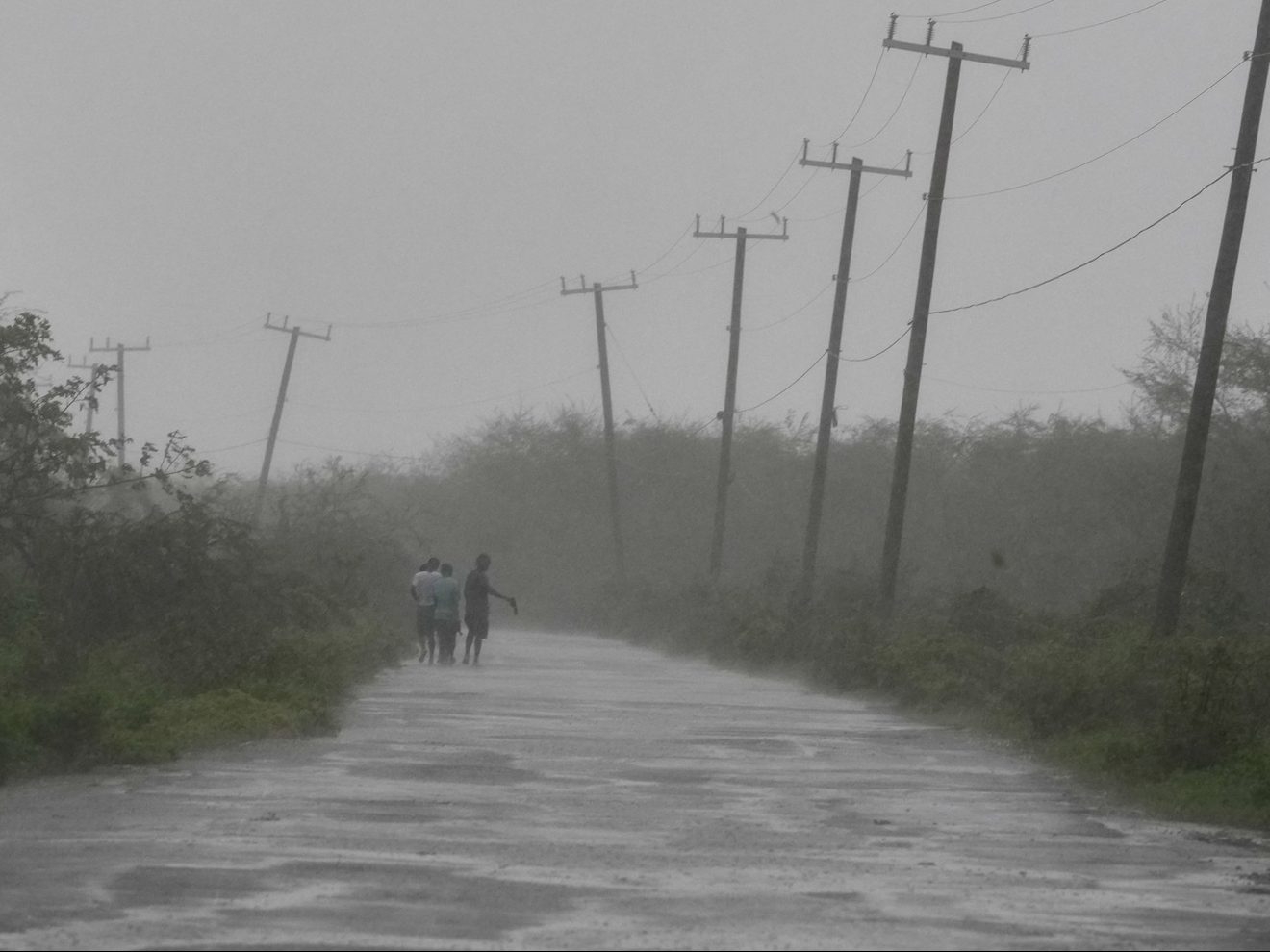 People walk along a road during the passing of Hurricane Melissa in Rocky Point, Jamaica, Tuesday, Oct. 28, 2025.  People walk along a road during the passing of Hurricane Melissa in Rocky Point, Jamaica, Tuesday, Oct. 28, 2025.