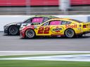 Joey Logano hopes to pass Ty Gibbs (left) during NASCAR Cup Series auto racing at Charlotte Motor Speedway one Sunday.